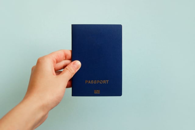 A Hand Holding A Passport