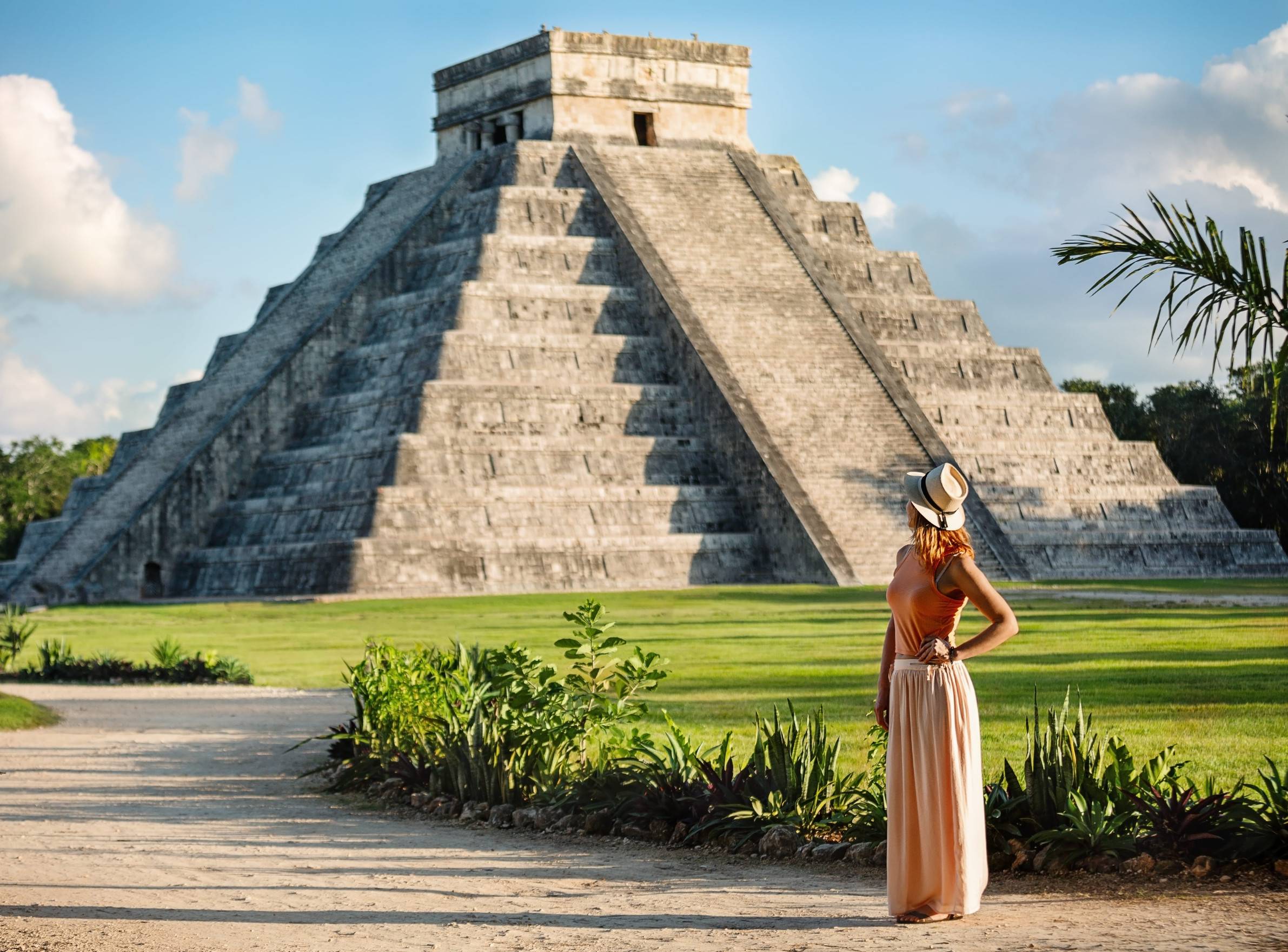 A girl standing in front of Chichen Itza