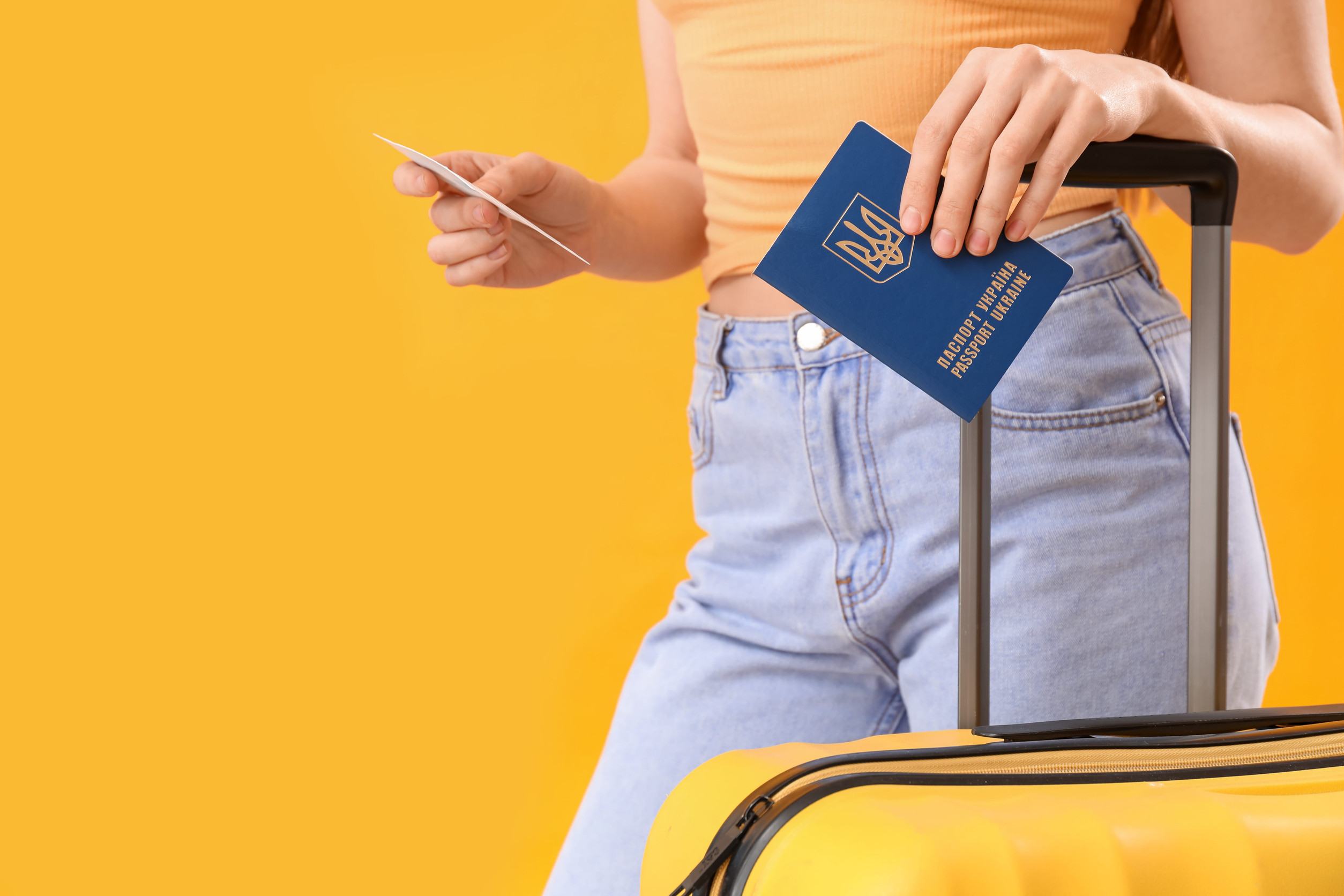 A woman holding a passport and luggage